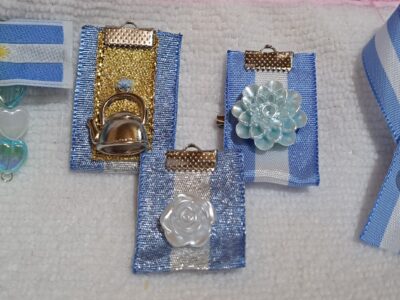 Rosarios y pulsera con dijes de San Benito y escarapelas
