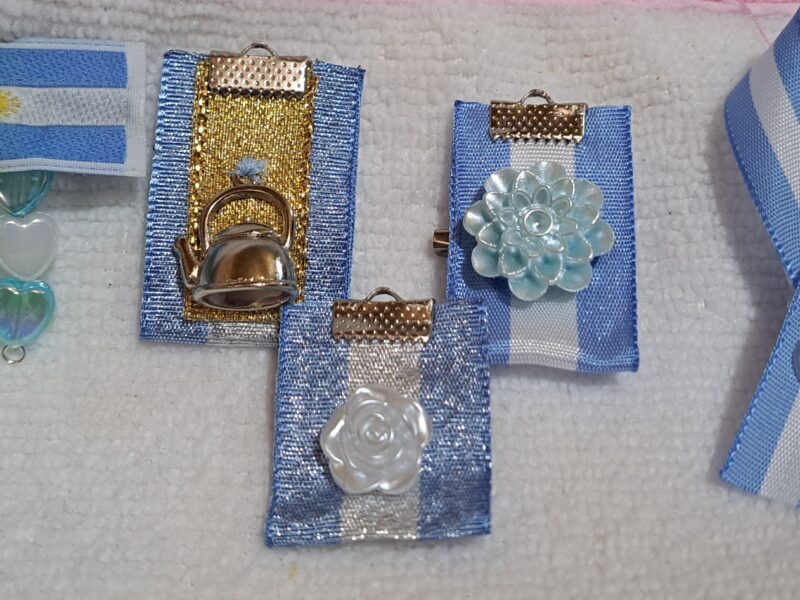 Rosarios y pulsera con dijes de San Benito y escarapelas